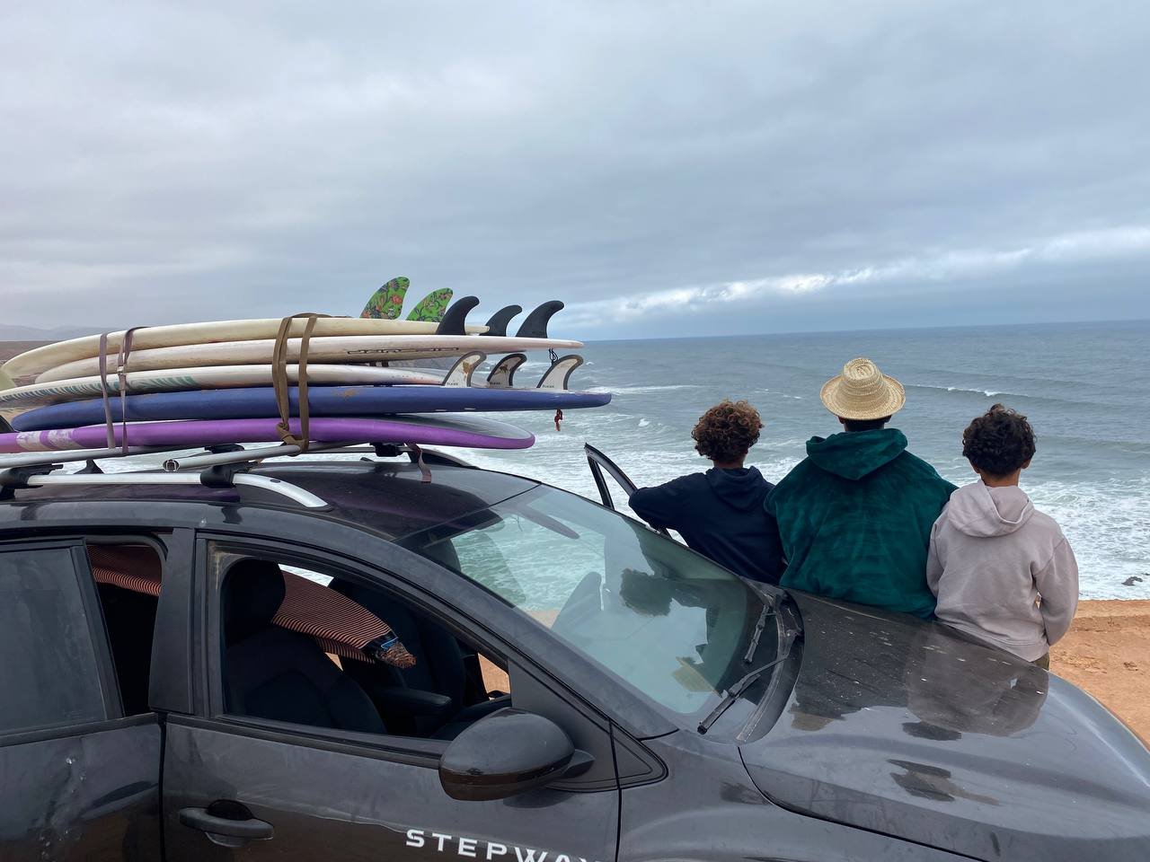 Surfboards on car roof overlooking the ocean